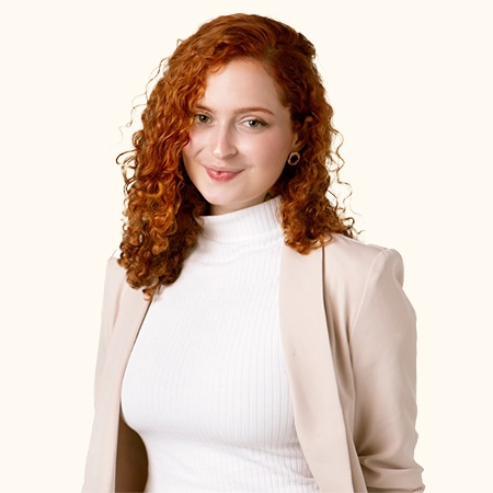 imagem com a foto da Larissa, de terninho bege e camisa branca, de gola alta, sorrindo